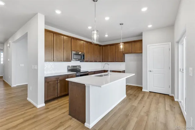 a large kitchen with stainless steel appliances granite countertop a lot of counter space and wooden floors