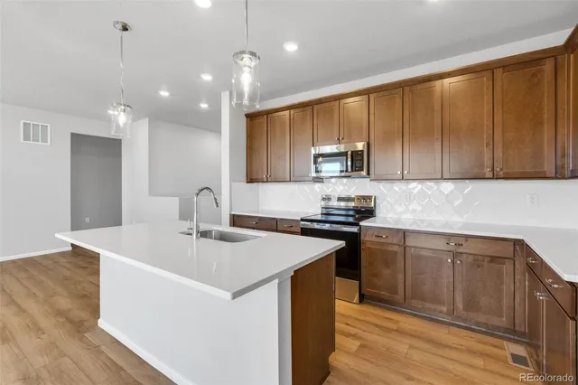 a kitchen with stainless steel appliances granite countertop a sink stove and refrigerator