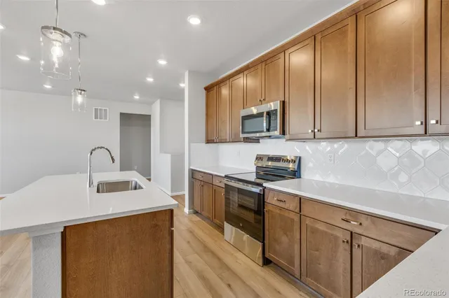 a kitchen with stainless steel appliances granite countertop a sink stove and cabinets