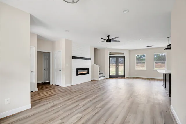 a view of a livingroom with wooden floor and a ceiling fan