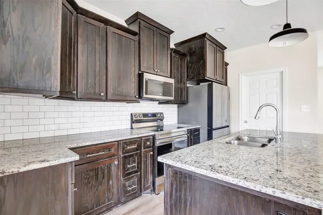 a kitchen with stainless steel appliances granite countertop a sink refrigerator and microwave