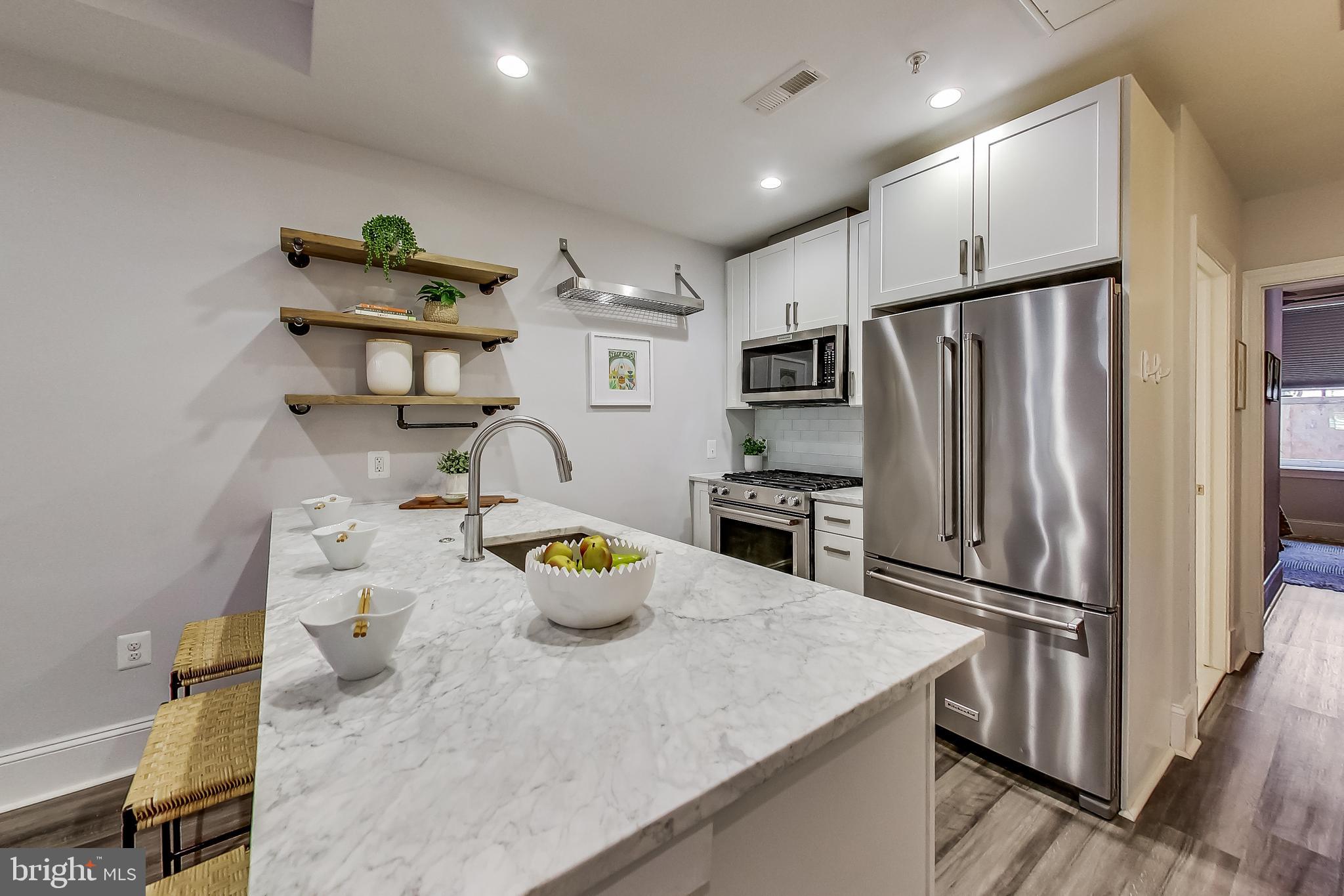 819 D Street Northeast, Unit 7 Washington, DC 20002 - Photo 5 of 20 a kitchen with stainless steel appliances a refrigerator a sink and a stove