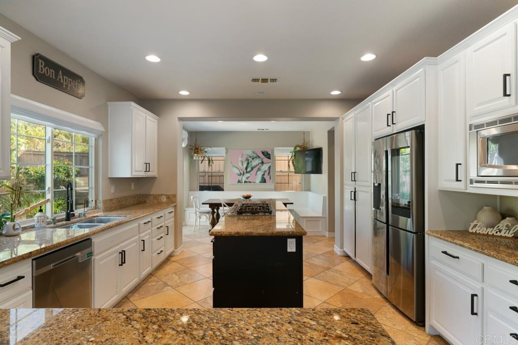 832 Genoa Way San Marcos, CA 92078 - Photo 19 of 42 a large kitchen with granite countertop a large counter top appliances and cabinets