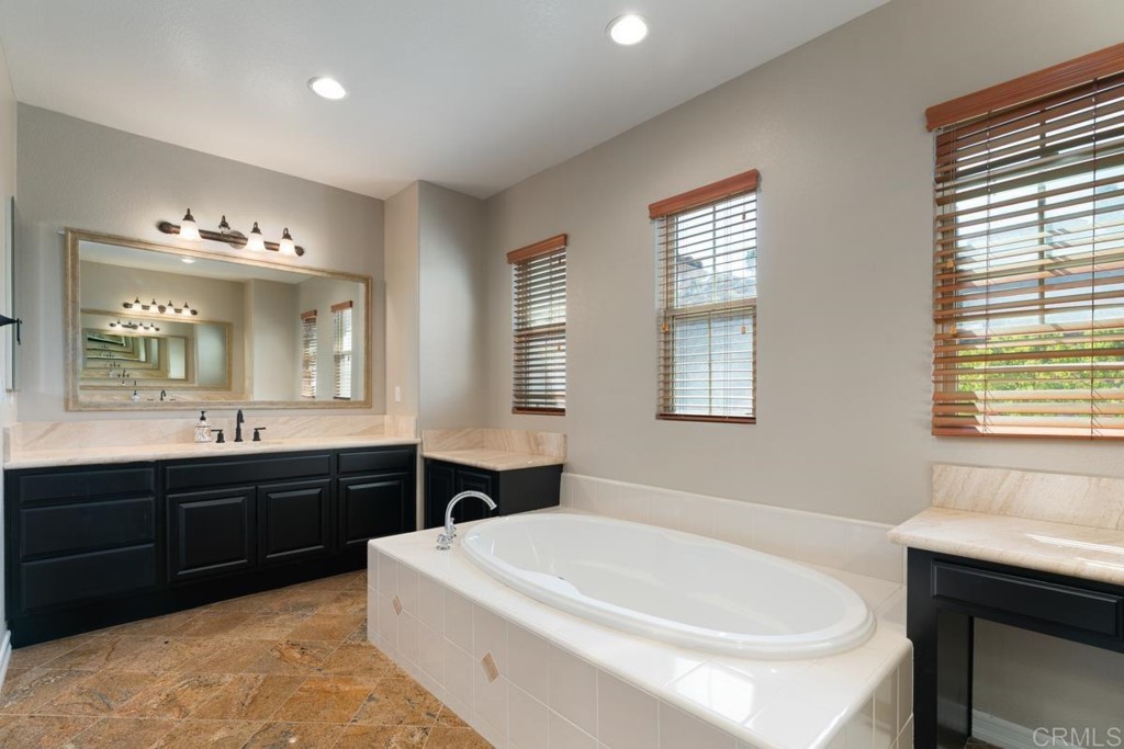832 Genoa Way San Marcos, CA 92078 - Photo 33 of 42 a spacious bathroom with a bathtub sink and mirror