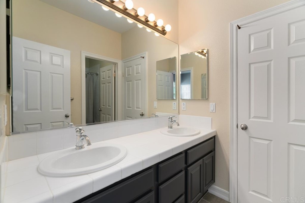 832 Genoa Way San Marcos, CA 92078 - Photo 36 of 42 a bathroom with a double vanity sink and a mirror
