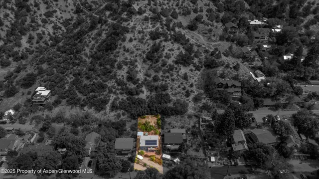 a aerial view of a house with table and chairs under an umbrella