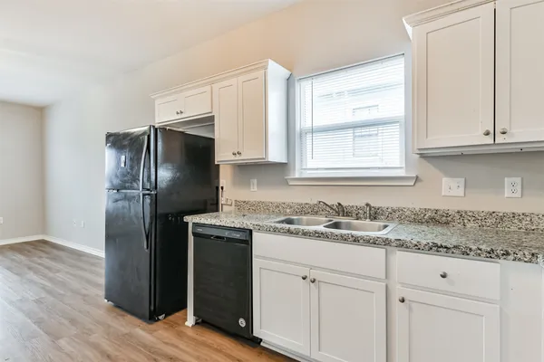 a kitchen with a refrigerator sink and cabinets