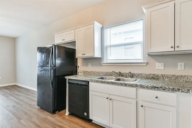 a kitchen with a refrigerator sink and cabinets