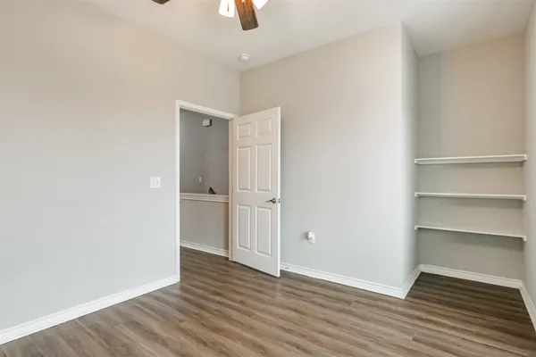 a view of an empty room with wooden floor