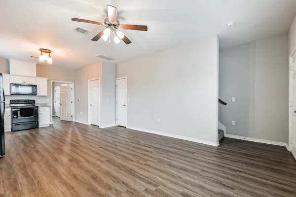 a view of a kitchen with a ceiling fan hardwood floor and a ceiling fan
