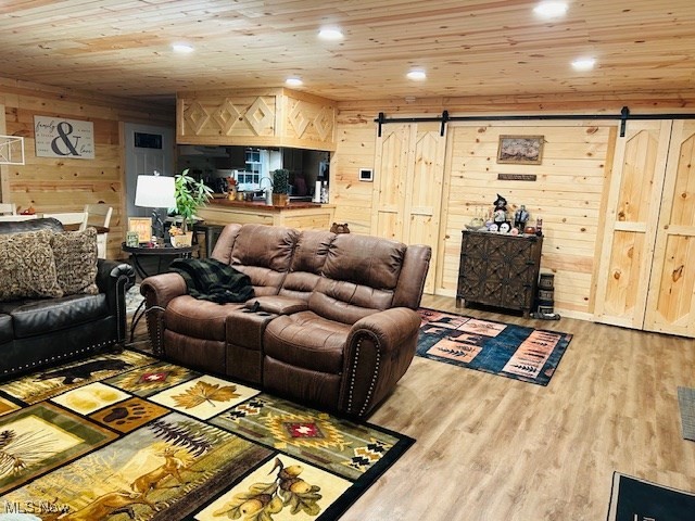 2445 McCord Hill Road Wellsburg, WV 26070 - Photo 20 of 37 Living area with a barn door, wooden ceiling, wood walls, light wood-style floors, and recessed lighting