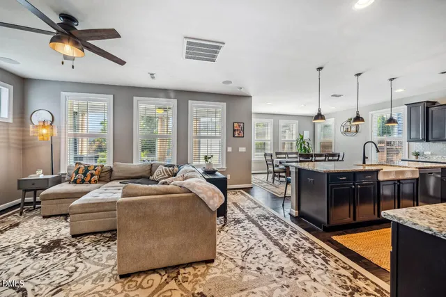 a large kitchen with granite countertop a stove a sink a center island and stainless steel appliances