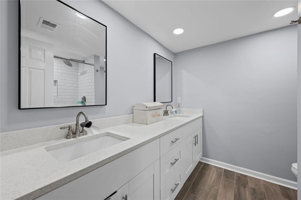 6851 Roswell Road, Unit E4 Atlanta, GA 30328 - Photo 15 of 26 a bathroom with a double vanity sink and mirror