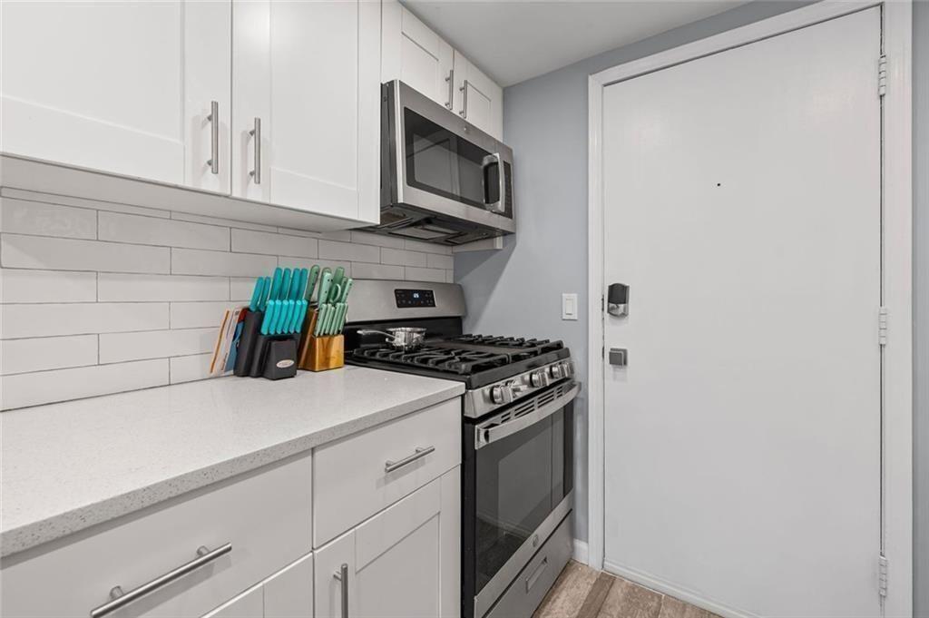 6851 Roswell Road, Unit E4 Atlanta, GA 30328 - Photo 5 of 26 a kitchen with stainless steel appliances a stove and a microwave