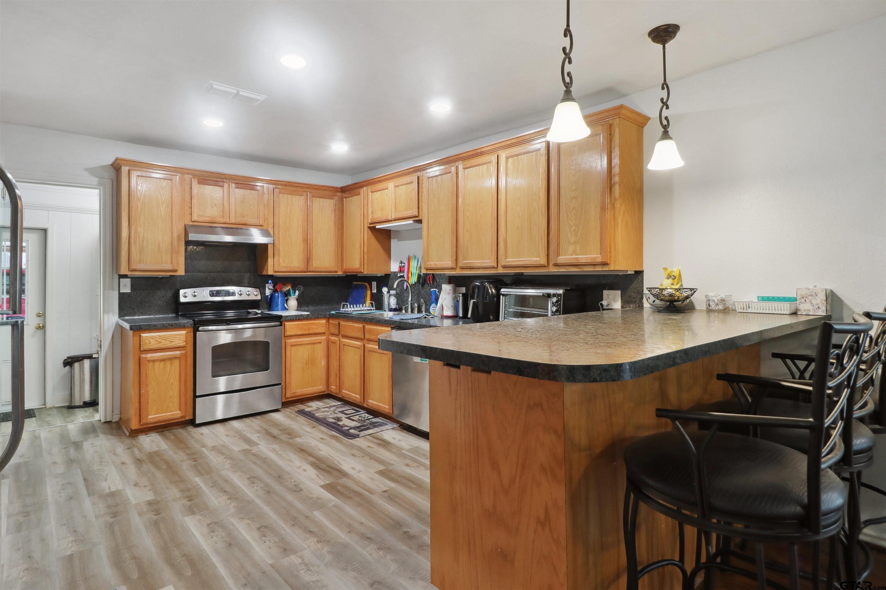 830 County Road 2201 Rusk, TX 75785 - Photo 19 of 40 a kitchen with granite countertop a stove a sink and a refrigerator