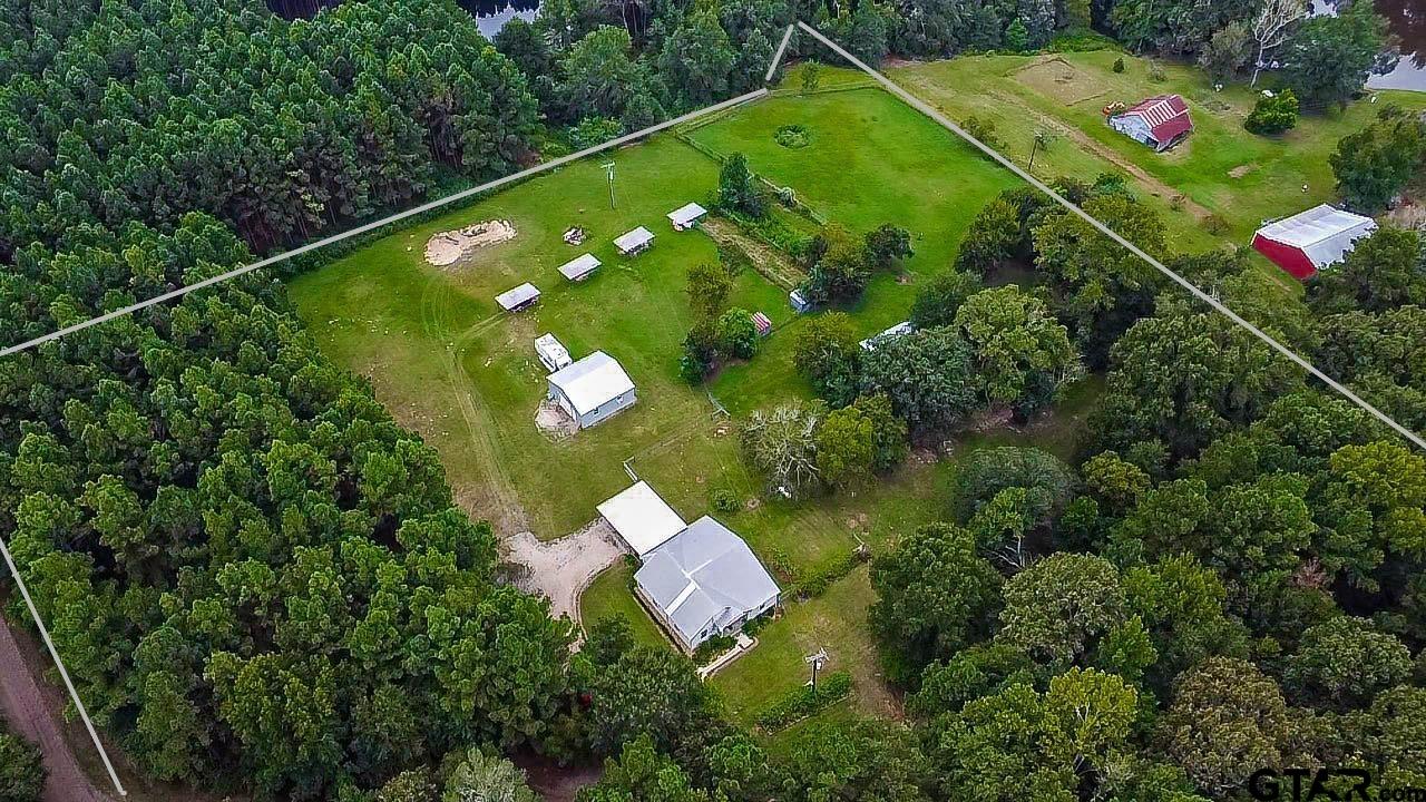 830 County Road 2201 Rusk, TX 75785 - Photo 2 of 40 a backyard of a house with lots of green space and plants