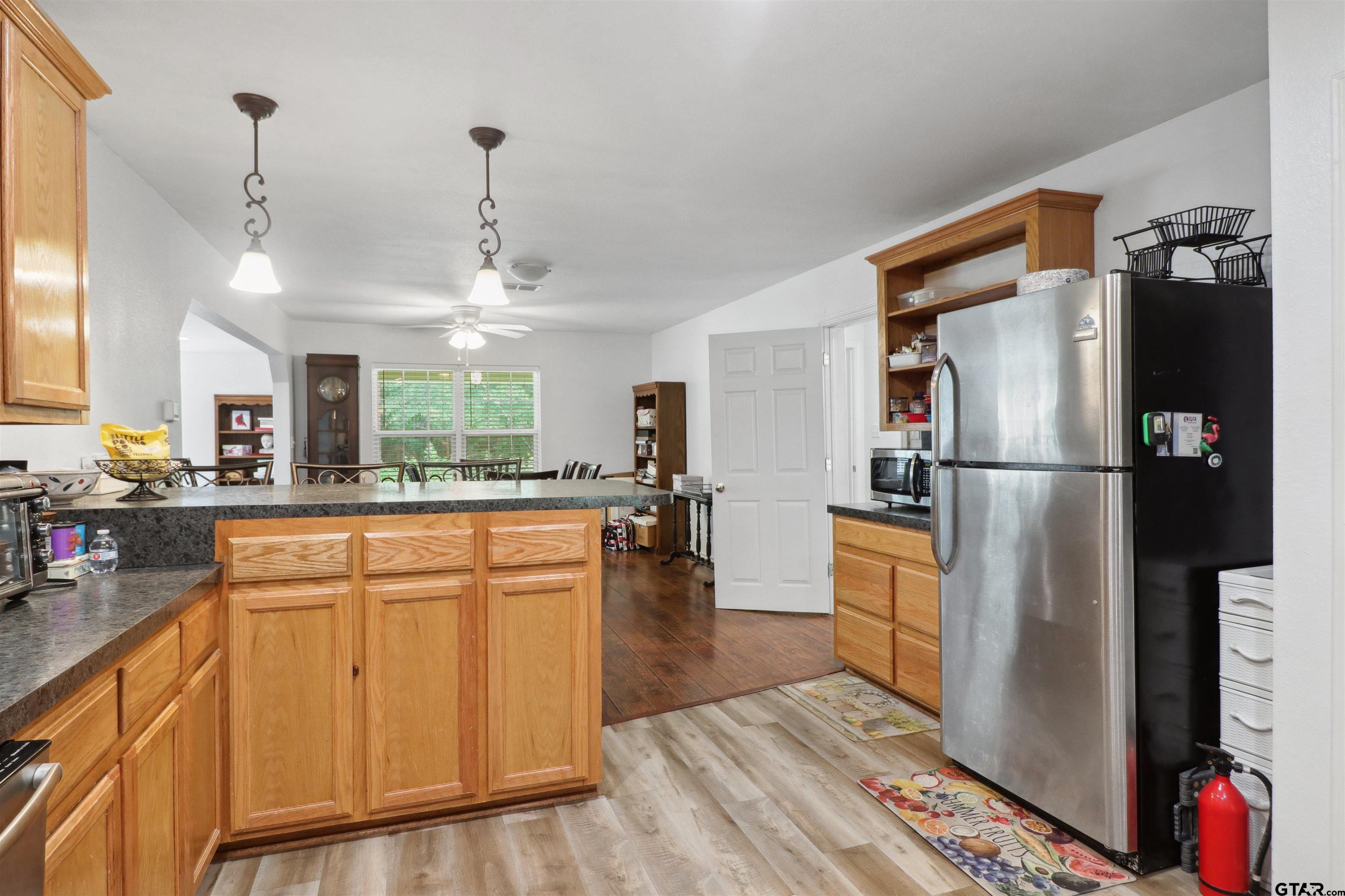 830 County Road 2201 Rusk, TX 75785 - Photo 21 of 40 a kitchen with stainless steel appliances granite countertop a refrigerator a sink dishwasher and a stove with wooden floor