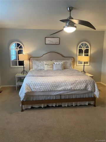 a bedroom with a bed a chandelier and a mirror