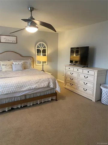 a bedroom with a bed and a flat tv screen on dresser