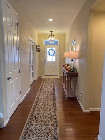 a view of a hallway with wooden floor windows and livingroom