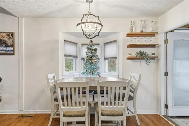 a view of a dining room with furniture wooden floor and a chandelier