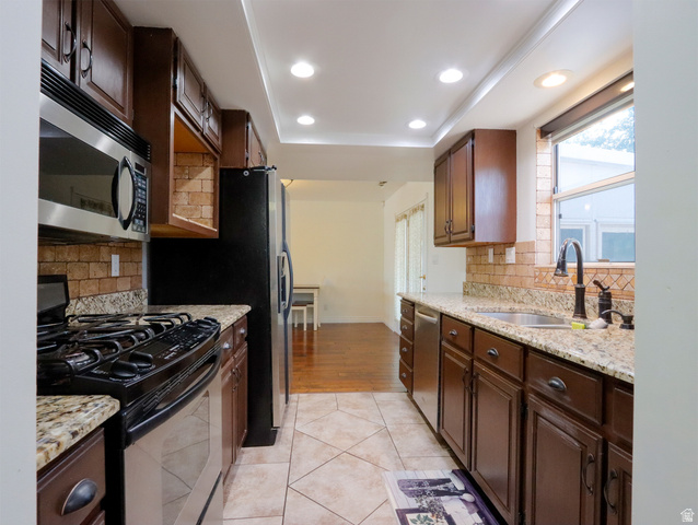 270 East 100 North Monroe, UT 84754 - Photo 17 of 65 Galley kitchen featuring recessed lighting, dark wood cabinetry, granite countertops, tile backsplash, and stainless steel appliances