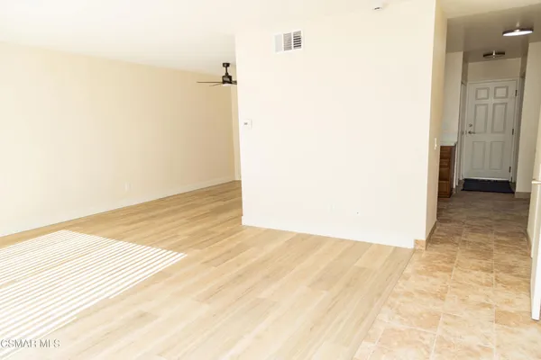 a view of an empty room with wooden floor