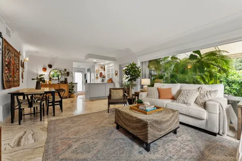 a bedroom with a bed a bookshelf and a large window