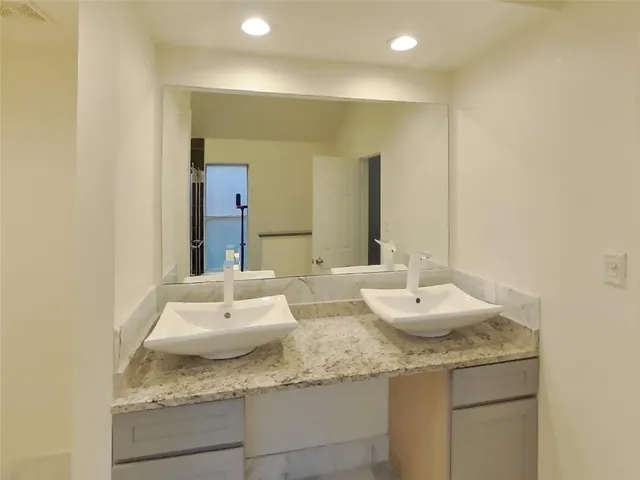 a bathroom with a granite countertop sink and a mirror