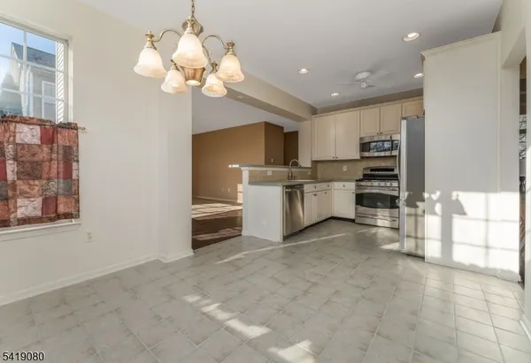a kitchen with stainless steel appliances a stove a refrigerator and a cabinets
