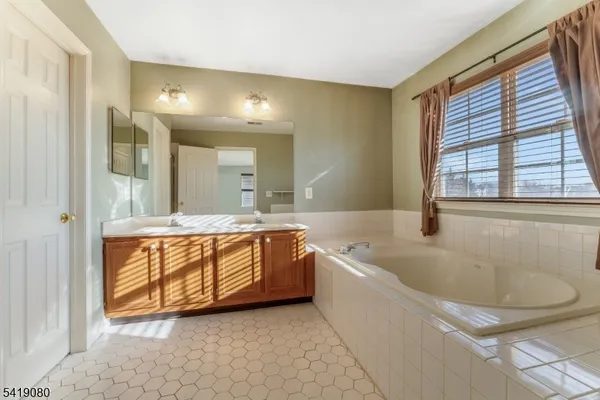 a spacious bathroom with sink shower and bathtub