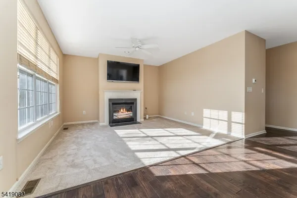 a view of empty room with a fireplace and windows