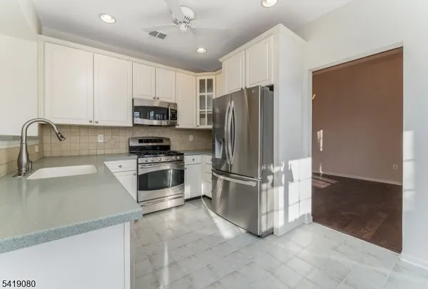 a kitchen with stainless steel appliances a refrigerator sink and microwave