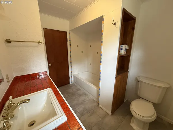 a bathroom with a tub and toilet