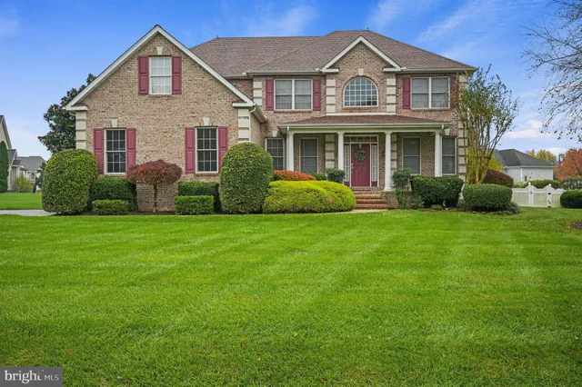 a front view of a house with a yard and green space