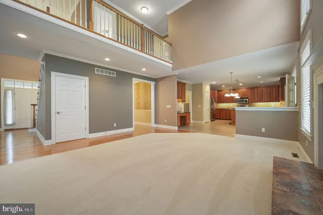 a view of an empty room and kitchen view