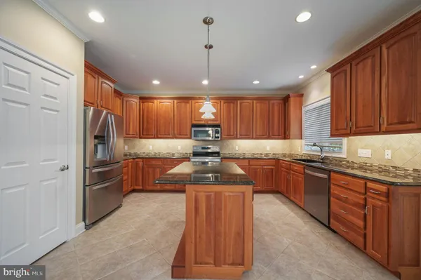a kitchen with granite countertop stainless steel appliances and wooden cabinets