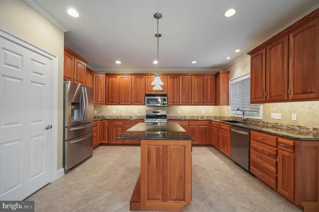 a kitchen with granite countertop stainless steel appliances and wooden cabinets