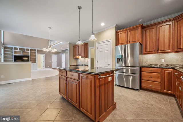 a kitchen with stainless steel appliances granite countertop a refrigerator a sink dishwasher a oven with wooden cabinets