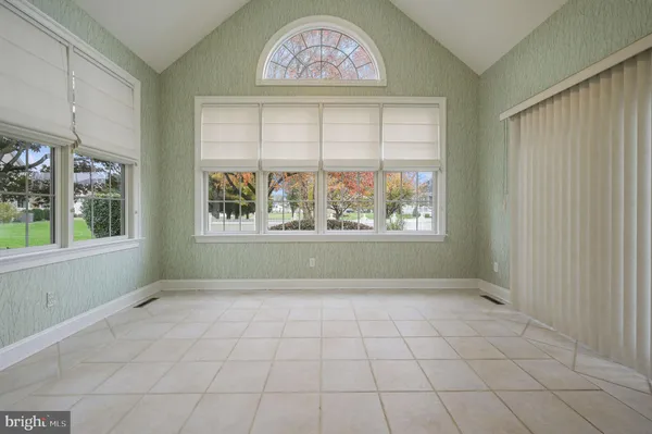 a view of an empty room with window and chandelier