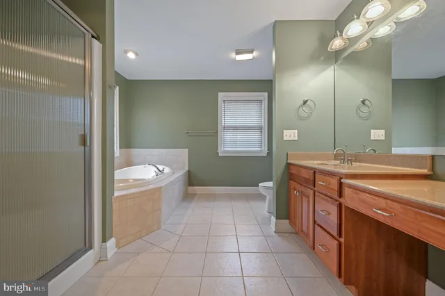 an empty room with windows and chandelier fan