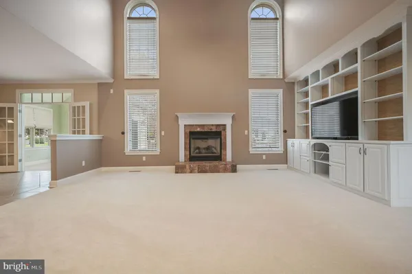 a view of an empty room with a fireplace and windows