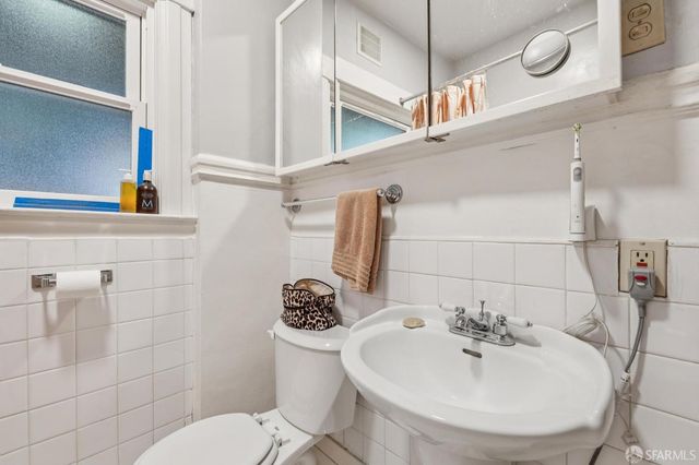 a bathroom with a sink a toilet and mirror