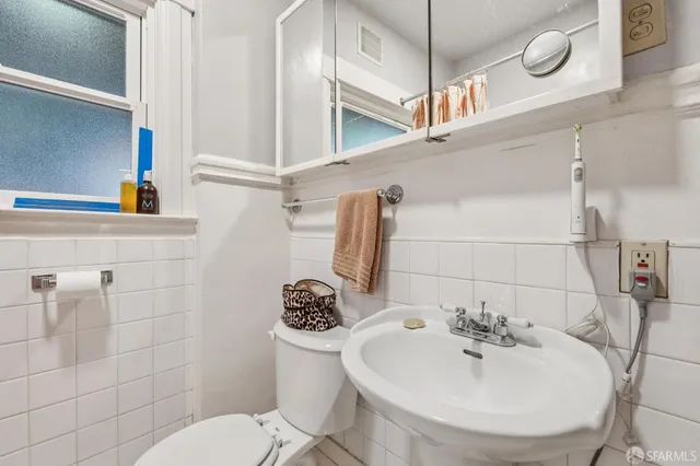 a bathroom with a sink a toilet and mirror