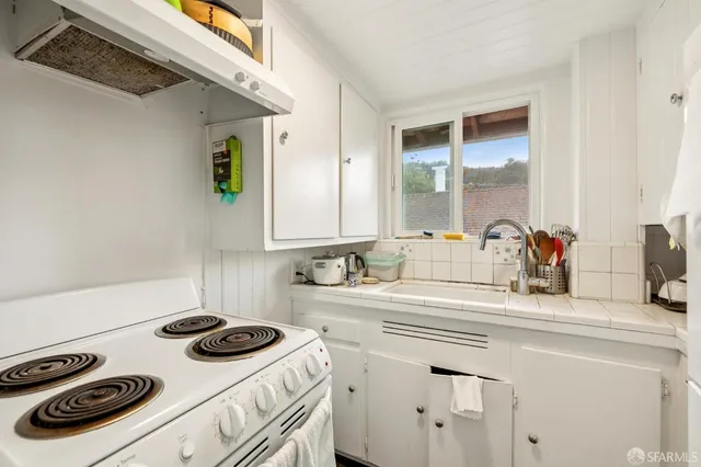 a kitchen with a sink stove and cabinets