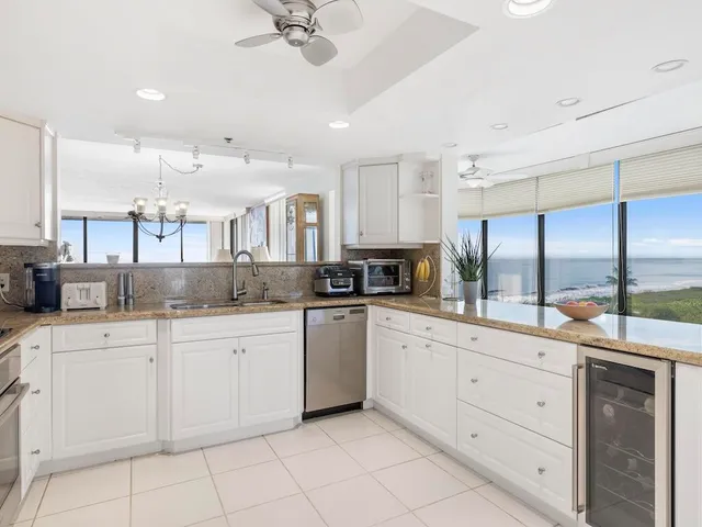 a kitchen with white cabinets and sink