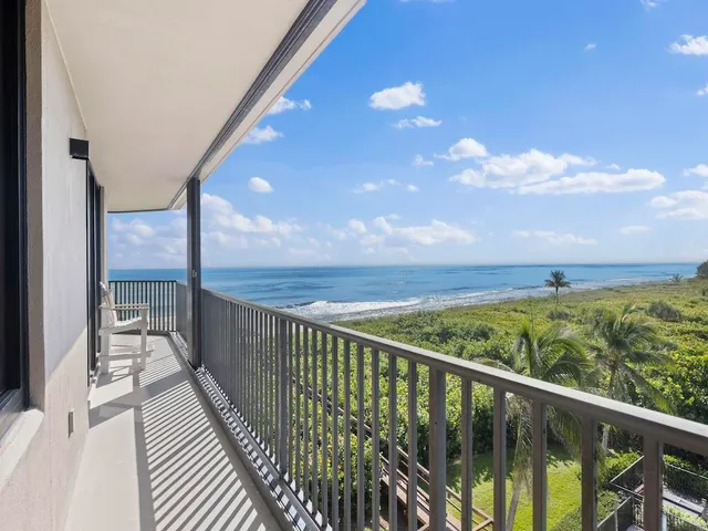 a view of a balcony with wooden floor & fence