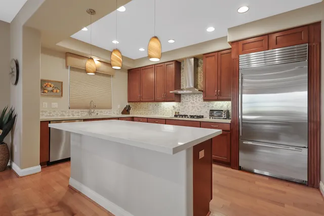 a kitchen with kitchen island granite countertop a sink and a refrigerator