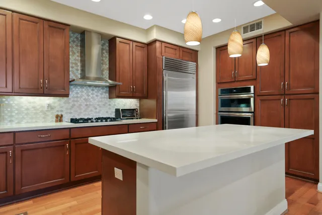 a kitchen with stainless steel appliances a refrigerator and a stove top oven
