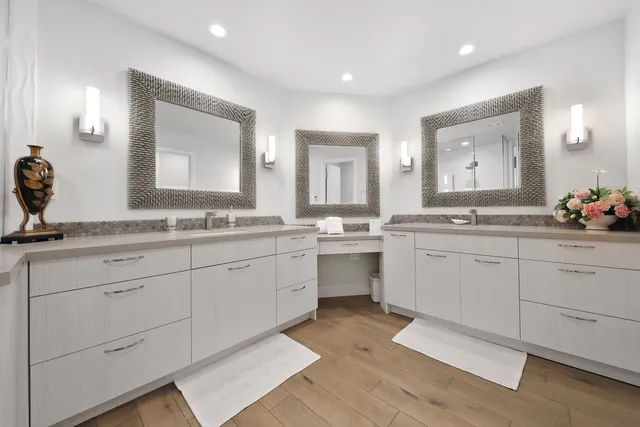 a spacious bathroom with double vanity and a mirror
